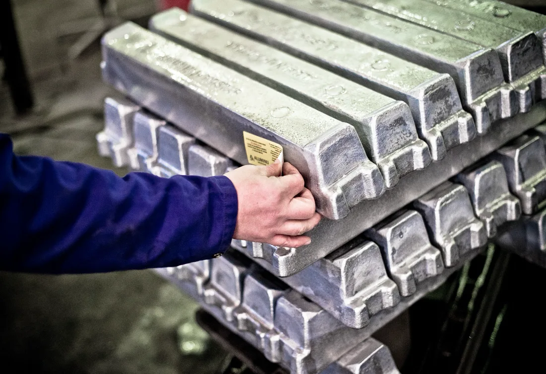 Close-up of stacked aluminium ingots receiving a stock identification label